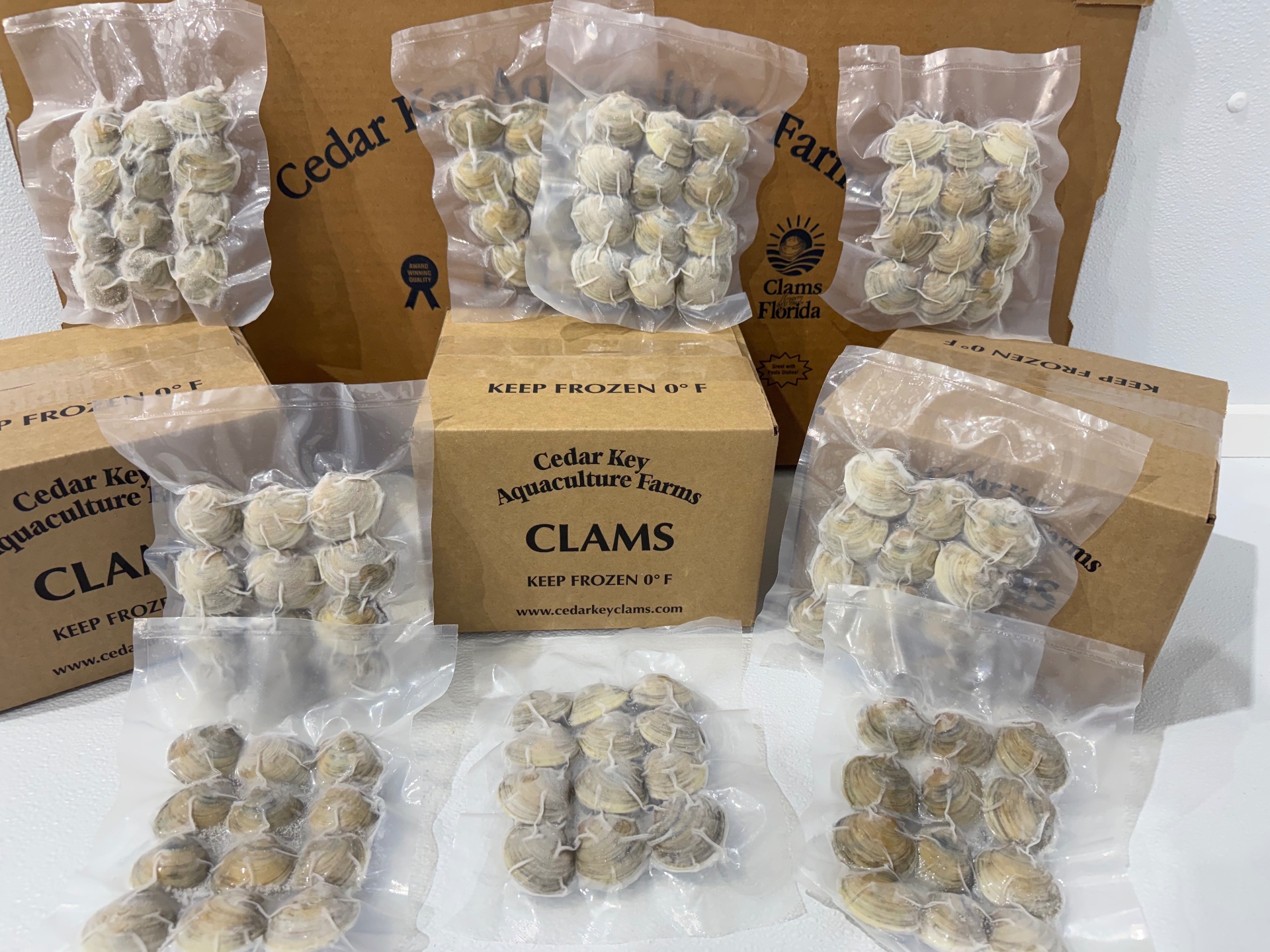 Vacuum-sealed IQF Cedar Key clams in branded Cedar Key Aquaculture Farms boxes